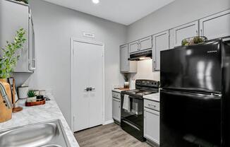 a kitchen with black appliances and white cabinets