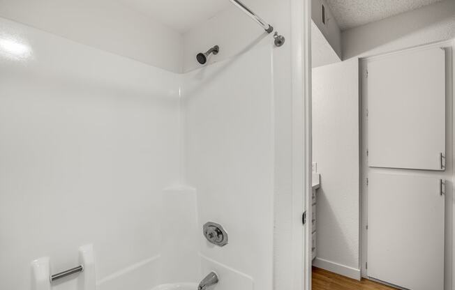 a bathroom with a white shower and a sliding glass door