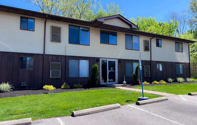 A building with a brown and beige exterior and a blue flag on a pole in front.