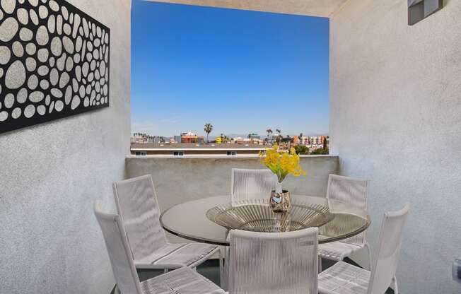 a table and chairs on a balcony with a view of the city