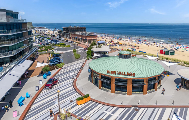 A view of a beachfront area with a large building that has the words "PIER VILLAGES" on it.