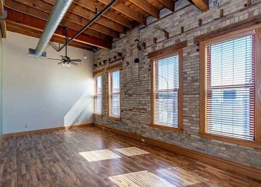 A room with wooden floors and a brick wall.