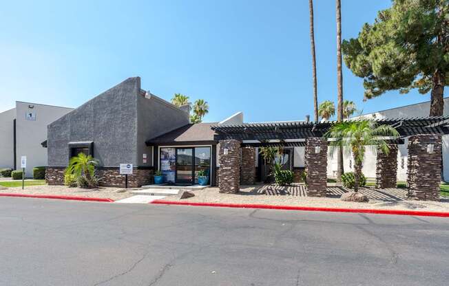 A building with a grey roof and a red stripe on the ground in front of it.