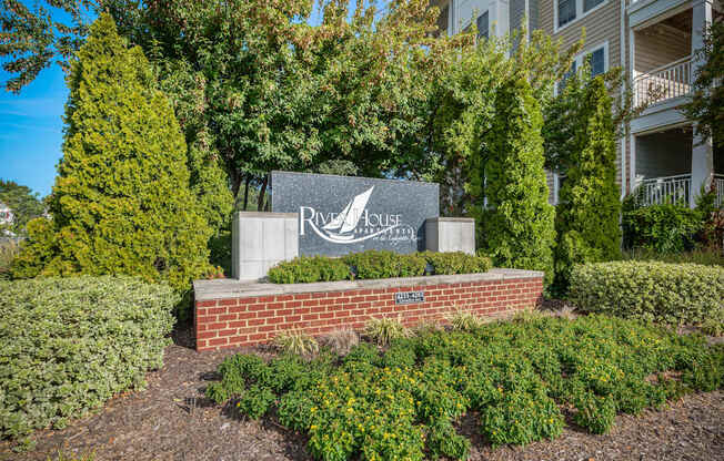 A sign for a place called River House is in front of a building.