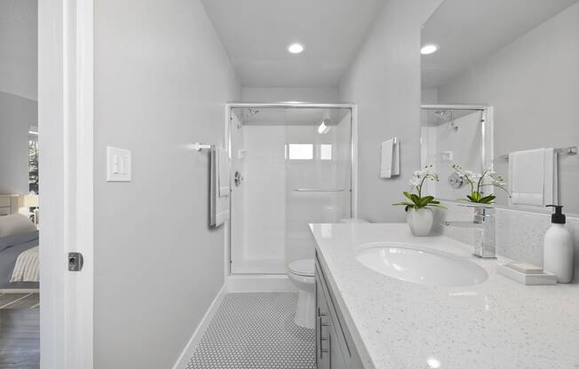 a white bathroom with a sink and a shower at The Fulton, Los Angeles