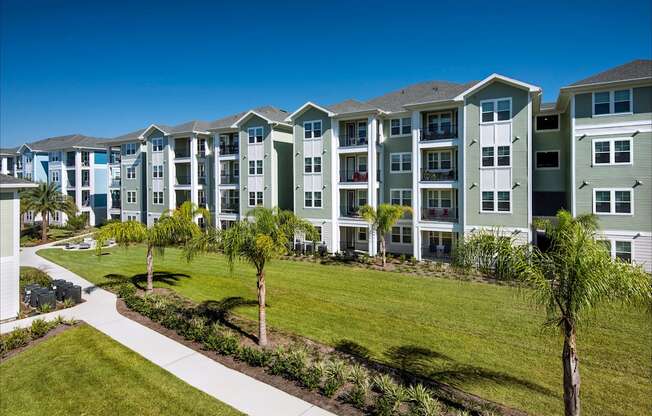 A row of apartment buildings with a walkway in front.