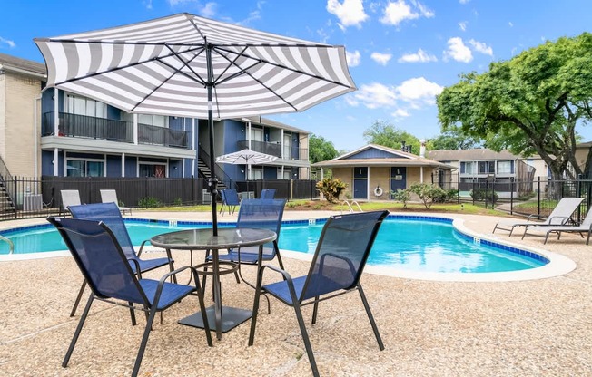 A patio with a table and chairs and an umbrella.