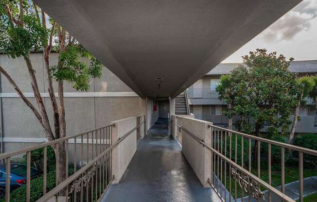 A long concrete walkway with a metal railing on both sides.