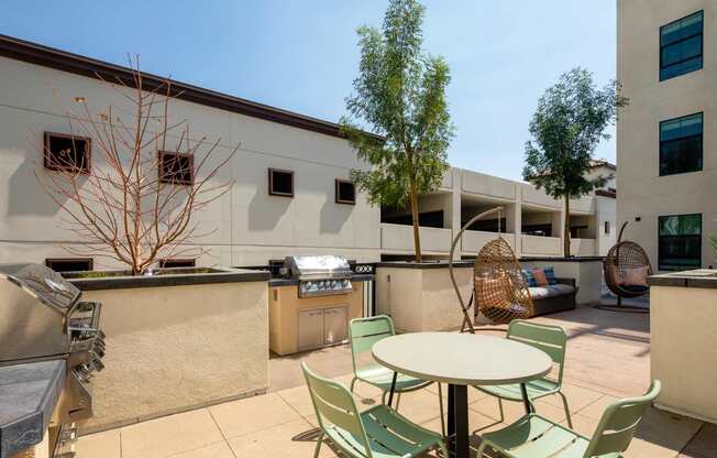 A patio with a table and chairs is surrounded by buildings.