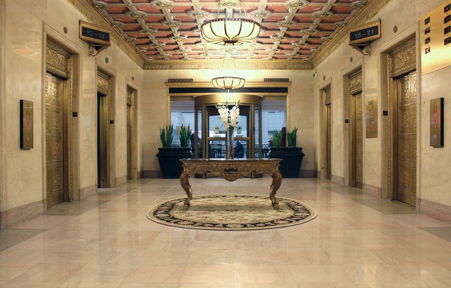 A hallway with a bench and a chandelier.