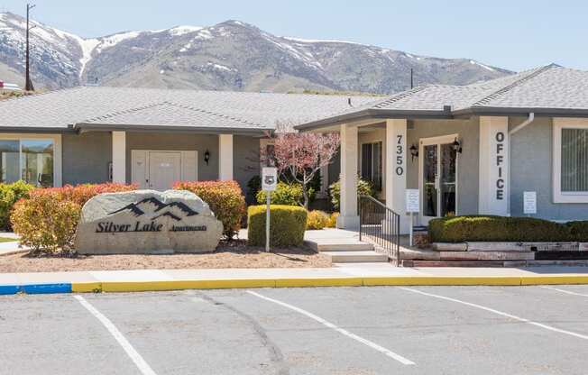a building with mountains in the background in a parking lot
