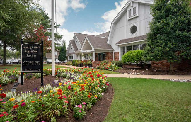 A sign for the Leasing Center & Resident Services at Waterfront is in front of a building.