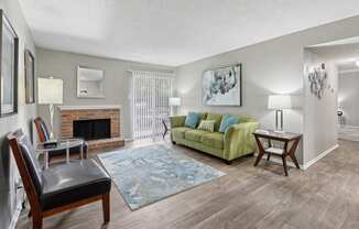 B1 living room with fireplace and green couch at Westdale Pointe in Austin, TX
