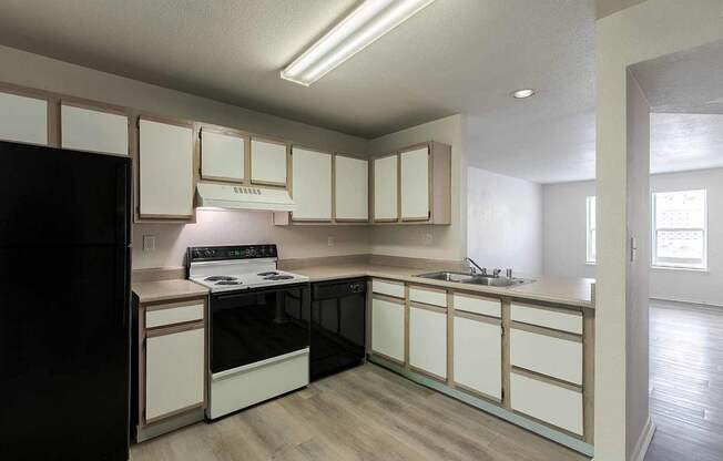 A kitchen with black appliances and white cabinets.