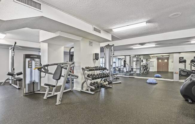 a gym with exercise equipment and weights on the floor