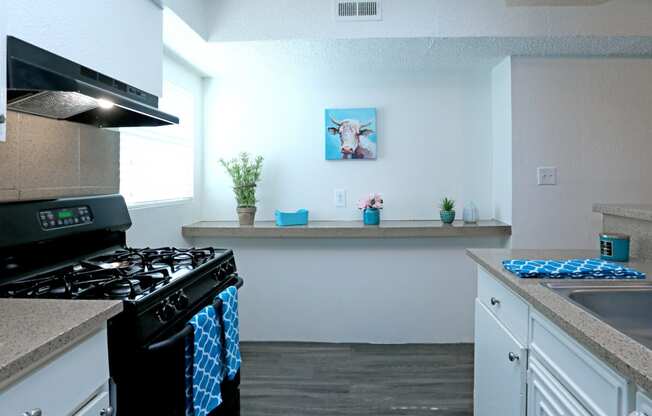 a kitchen with white cabinets and a black stove top oven