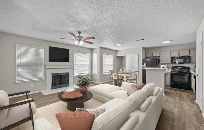 A living room with a white couch and a fireplace.