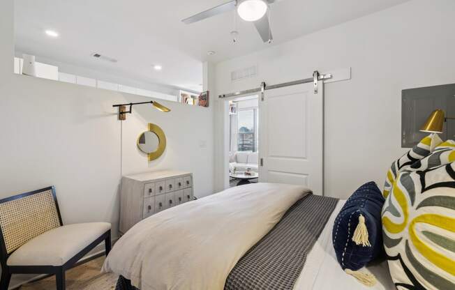 a bedroom with a bed and a dresser and a door to a bathroom at Link Apartments® Broad Ave, Memphis