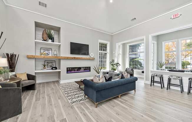 Community Clubhouse with Lounge Furniture and Fireplace at Bridges at Oakbend Apartments in Lewisville, TX.