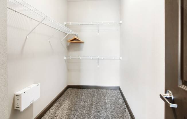 a walk in closet with white walls and a white dryer in it