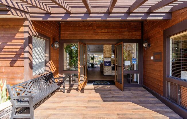 A wooden deck with a bench and a table.