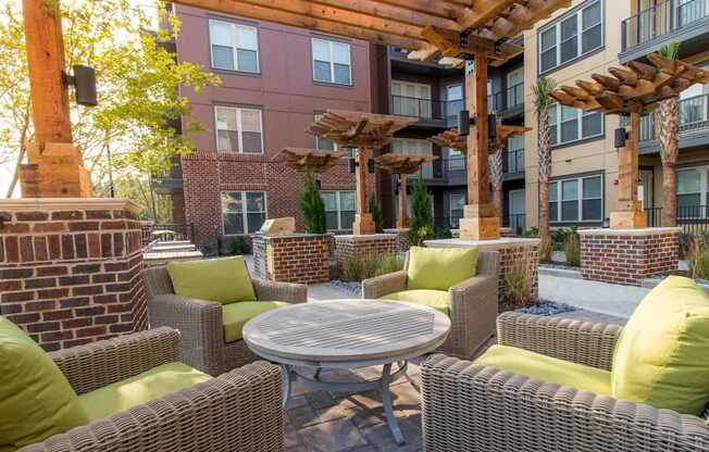A patio with a table surrounded by chairs and a pergola.