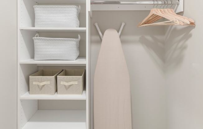 a walk in closet with shelves and a white shelf with a surfboard in it