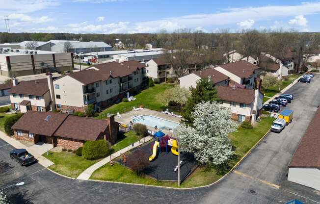 an aerial view of a neighborhood of houses with a playground and a pool