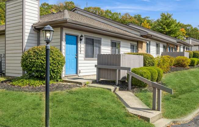 a house with a blue door and a wooden bench in front of it