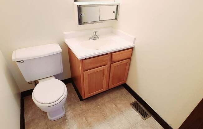 A white toilet sits next to a sink in a small bathroom.