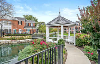 A gazebo is surrounded by flowers and a walkway.