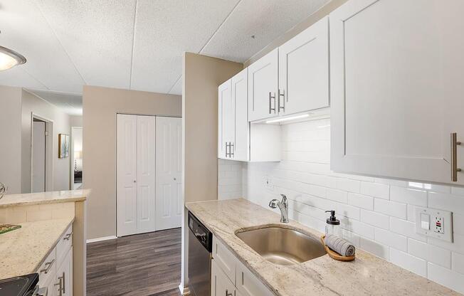 a kitchen with white cabinets and a sink at Troy Place Apartments - Troy, MI, Michigan