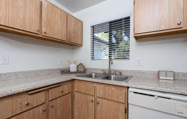 A kitchen with wooden cabinets and a granite countertop.