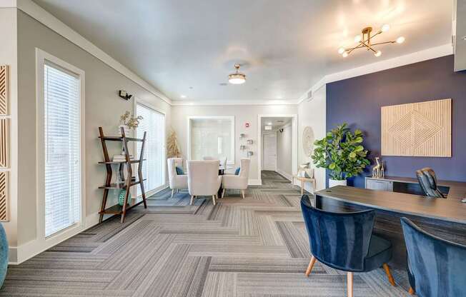 A modern office space with a grey carpet and blue chairs.