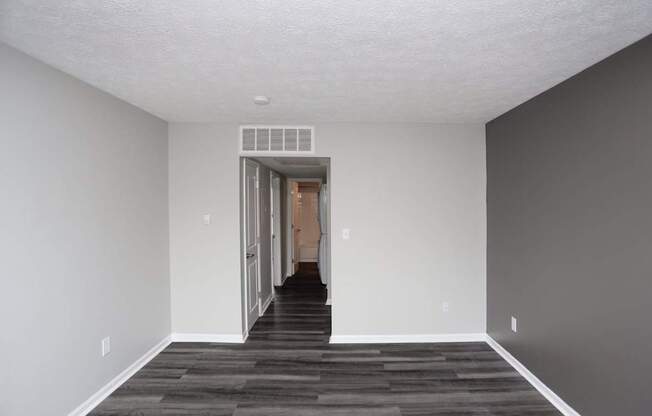 A room with a white ceiling and a doorway leading to another room.