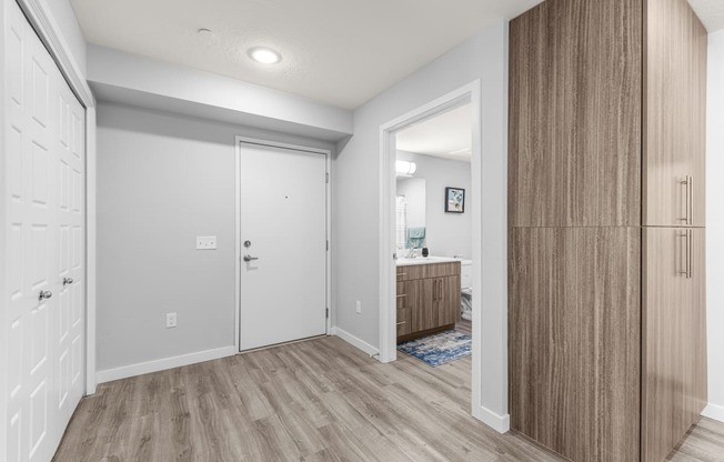 a hallway with a door to a bathroom and a closet
