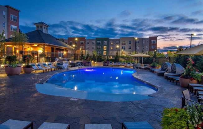 a swimming pool at night at a hotel with a blue pool