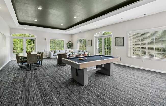 A spacious room with a pool table and a dining table.