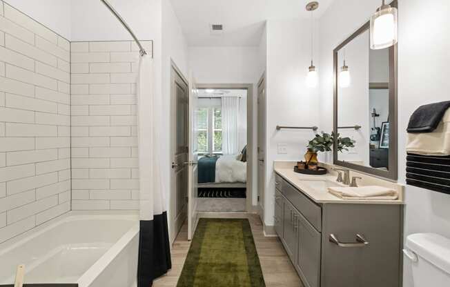 a white bathroom with a tub and a sink and a mirror