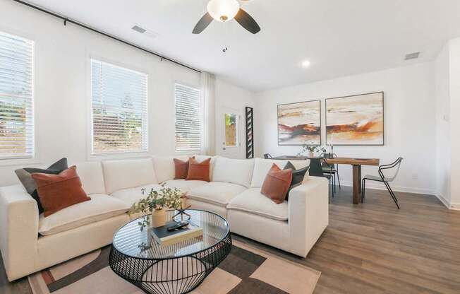a living room with couches and a glass coffee table