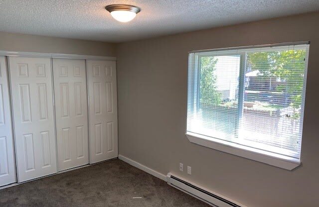 an empty room with a large window and two closets