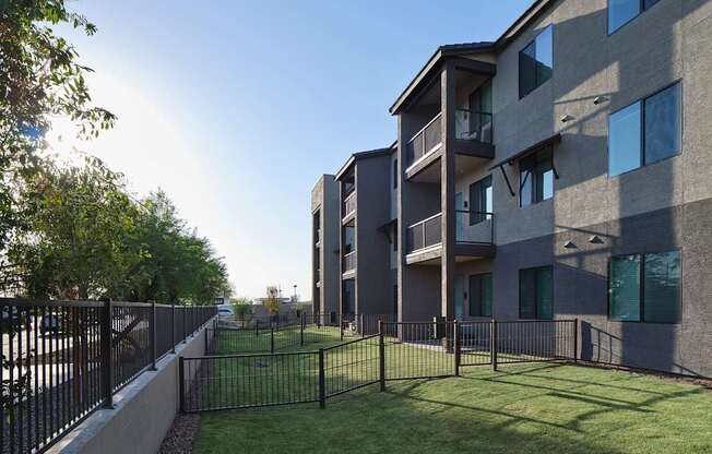 an apartment building with a yard and a fence