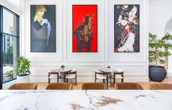 Art-lined community lounge with café seating and marble-topped tables, reflecting Nashville’s creative spirit and gallery-inspired design.