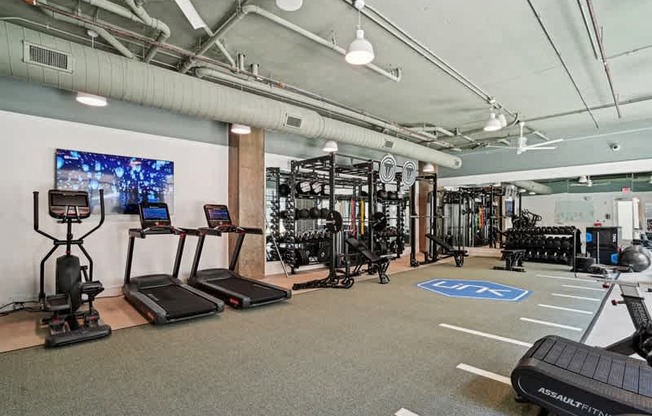 a workout room with weights and other exercise equipment in a building