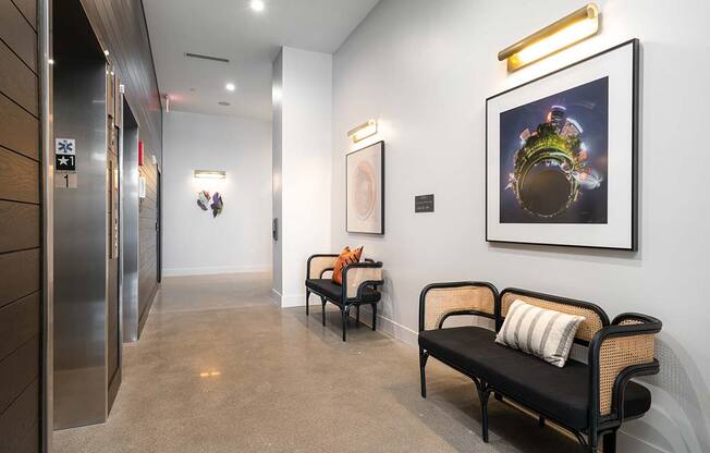 a hallway with two chairs and a painting on the wall   at The Bohen Apartments, Minneapolis