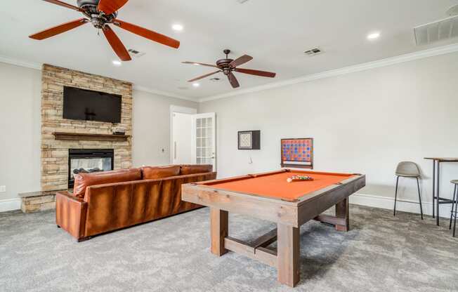 a living room with a pool table and a fireplace