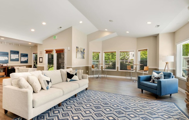 a living room with a white couch and a blue chair