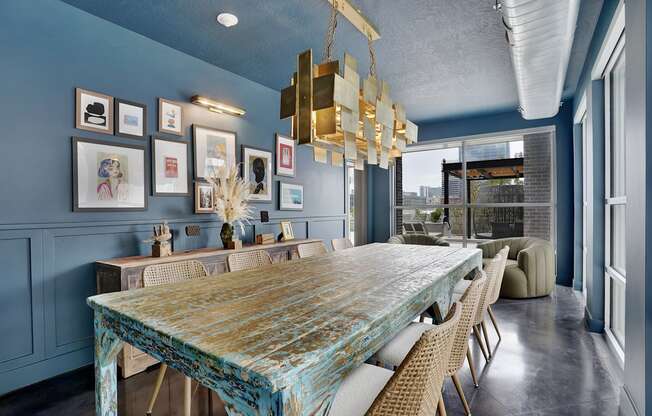 A dining room with a blue table and chairs.