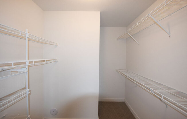 a walk in closet with wardrobe organizers