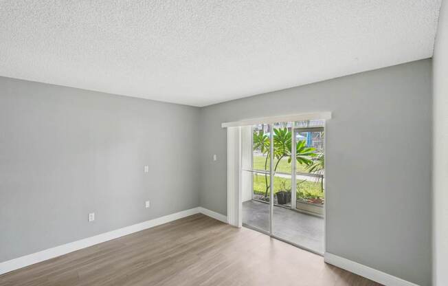 A room with a sliding glass door leading to a balcony.